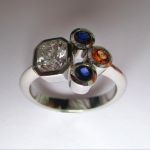 1 Carat Radiant Cut Diamond with Blue and Orange Sapphires set in Platinu